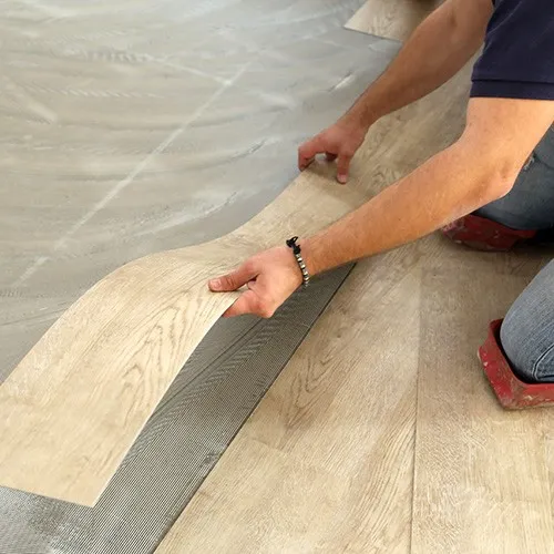 On-Vinyl-Install Worker installing vinyl | Howard-Carpenter Floor Covering