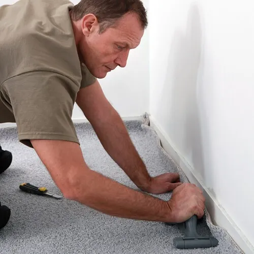 carpet_install_img Worker installing carpet | Howard-Carpenter Floor Covering