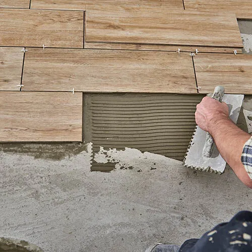 tile-install-image Worker installing tile | Howard-Carpenter Floor Covering